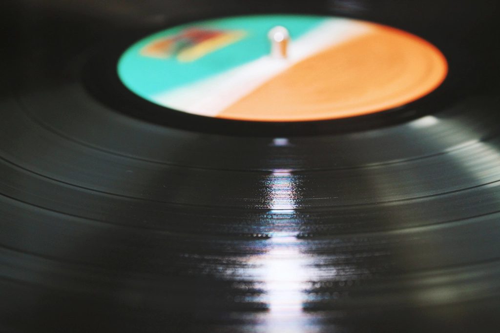 A vinyl record turning under low light, the label catching the light